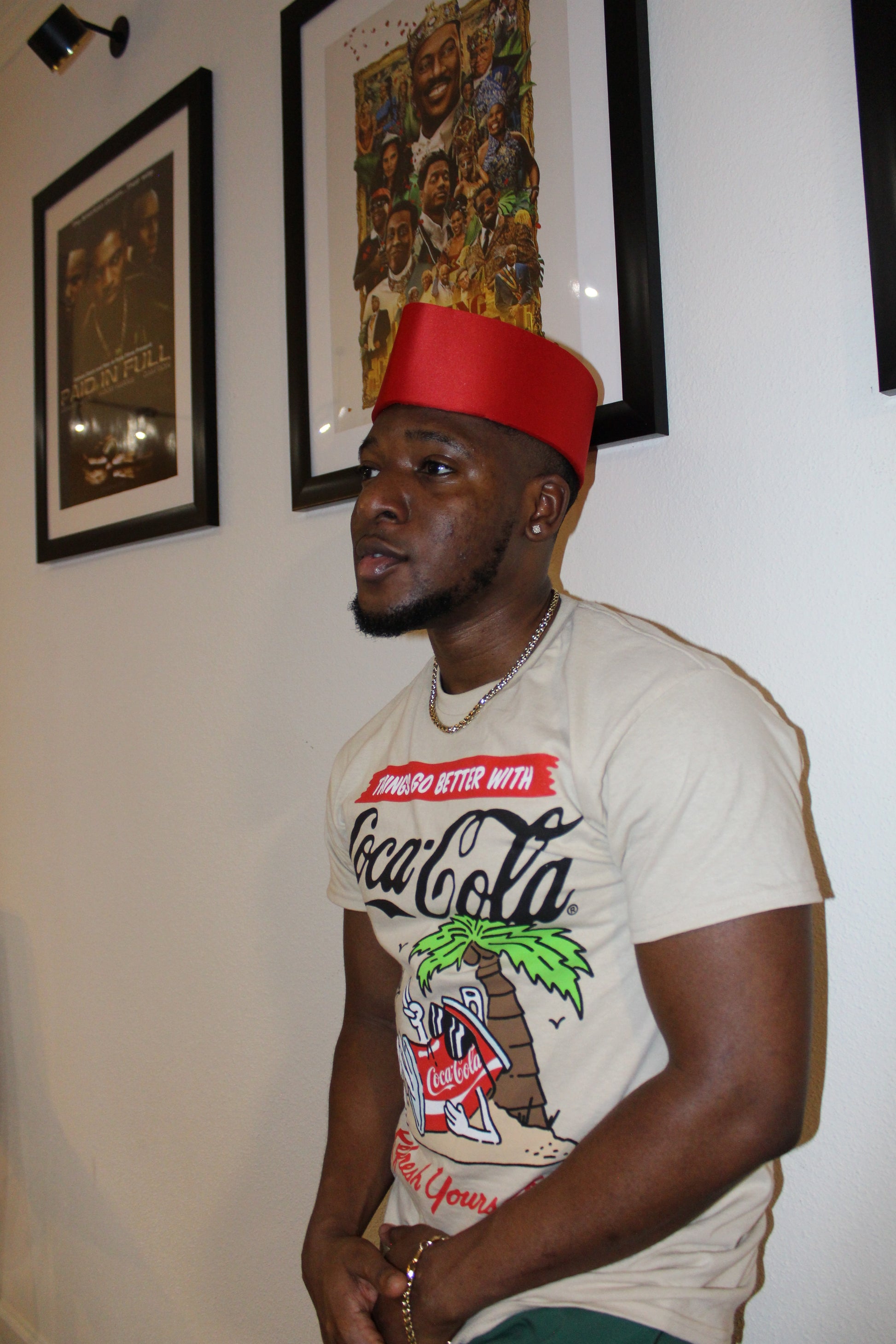 Person wearing a graphic t-shirt with various designs on a white surface.